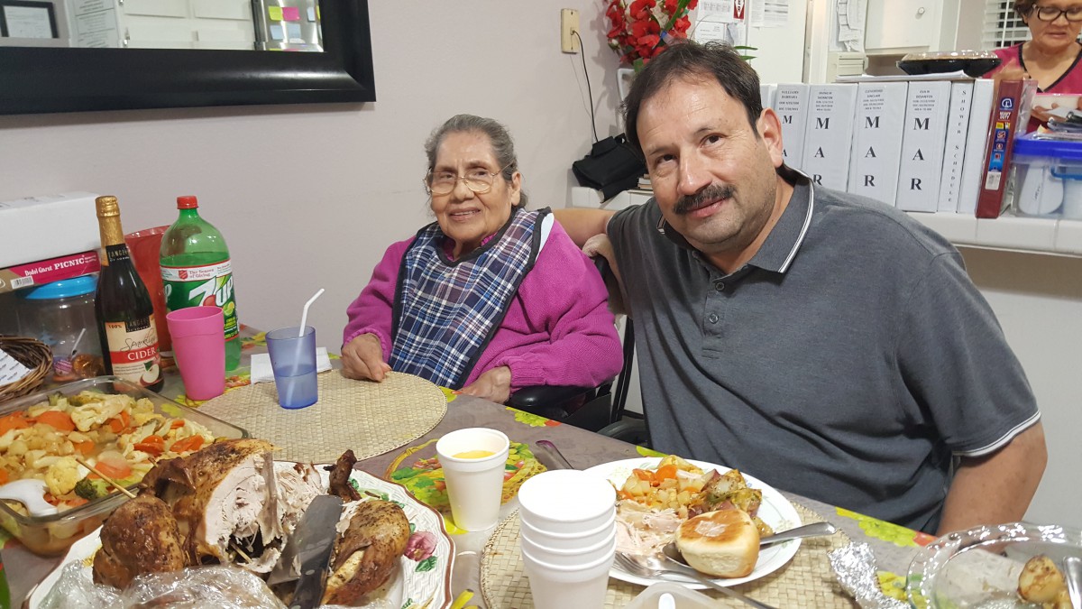 Two people seated at a dining table, enjoying a meal together.
