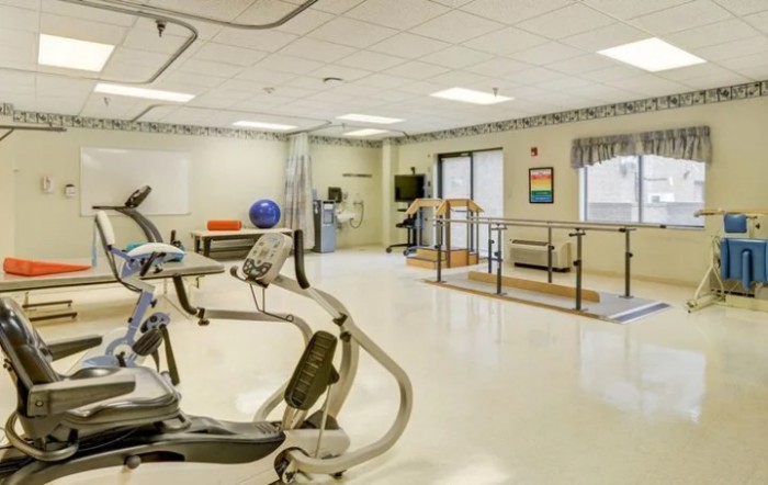A rehabilitation and therapy room equipped with exercise machines and physical therapy tools.