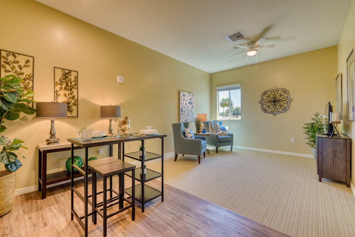 A modern living room with stylish furniture and decor, featuring a small dining table and a cozy seating area.