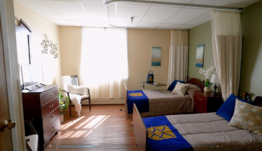 A bright and inviting bedroom with two beds, decorated in calming colors and illuminated by natural light.