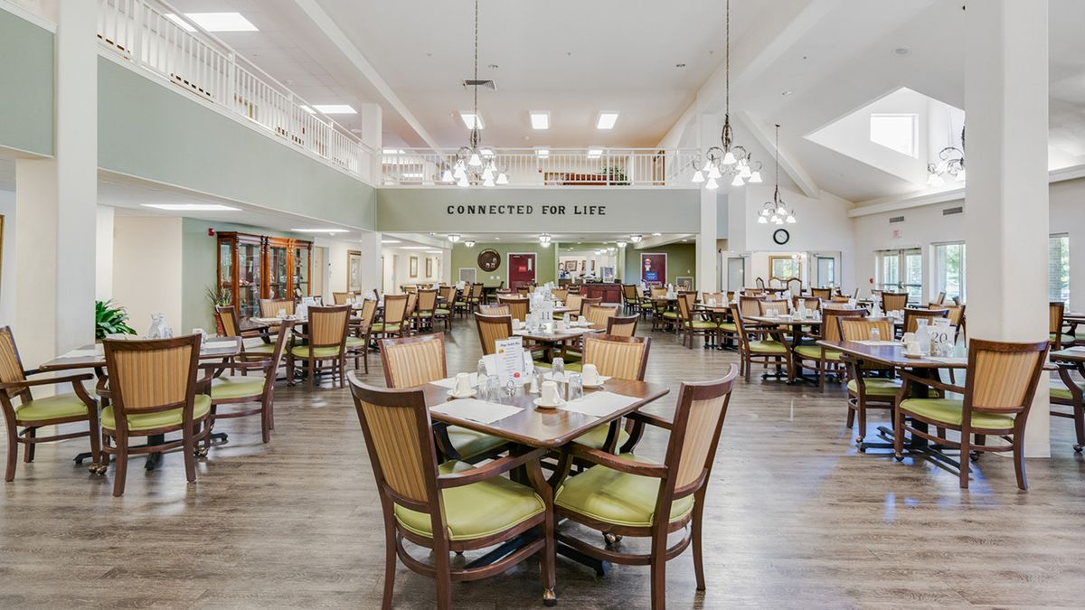 A spacious and well-lit dining area with neatly arranged tables and chairs.