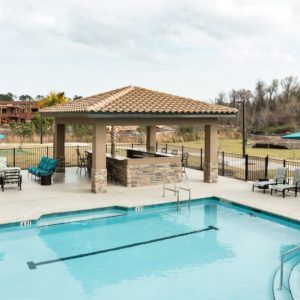 Outdoor swimming pool area with a gazebo and seating.