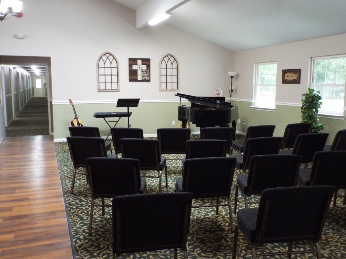 Interior view of a small church or chapel with musical instruments and chairs set up for a service or event.
