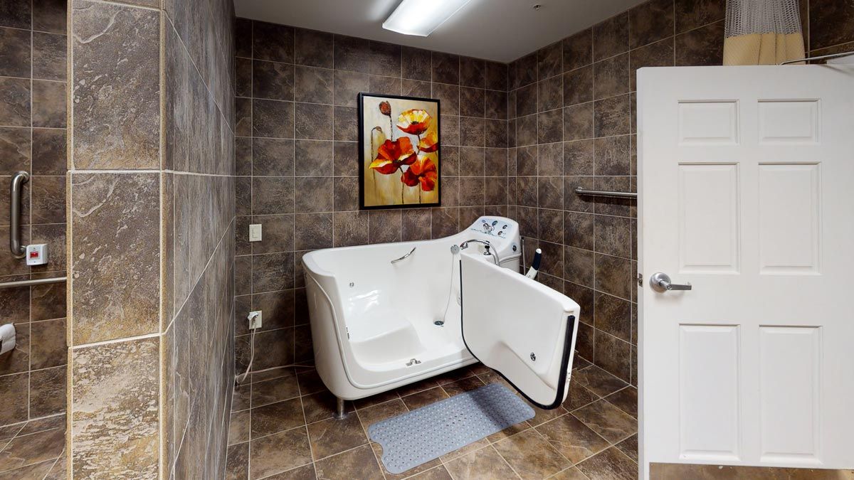 A modern bathroom featuring a walk-in bathtub with tiled walls and an abstract painting.