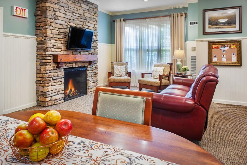 A cozy living room with a stone fireplace, television, and comfortable seating.