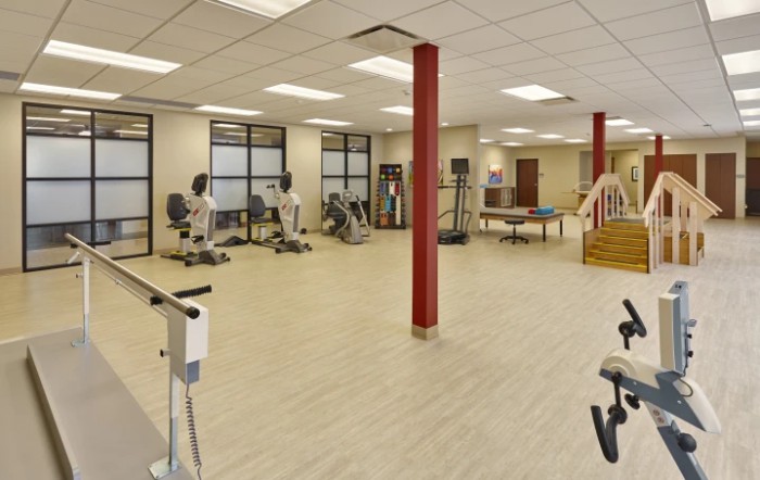 A spacious gym with exercise equipment and rehabilitation facilities.