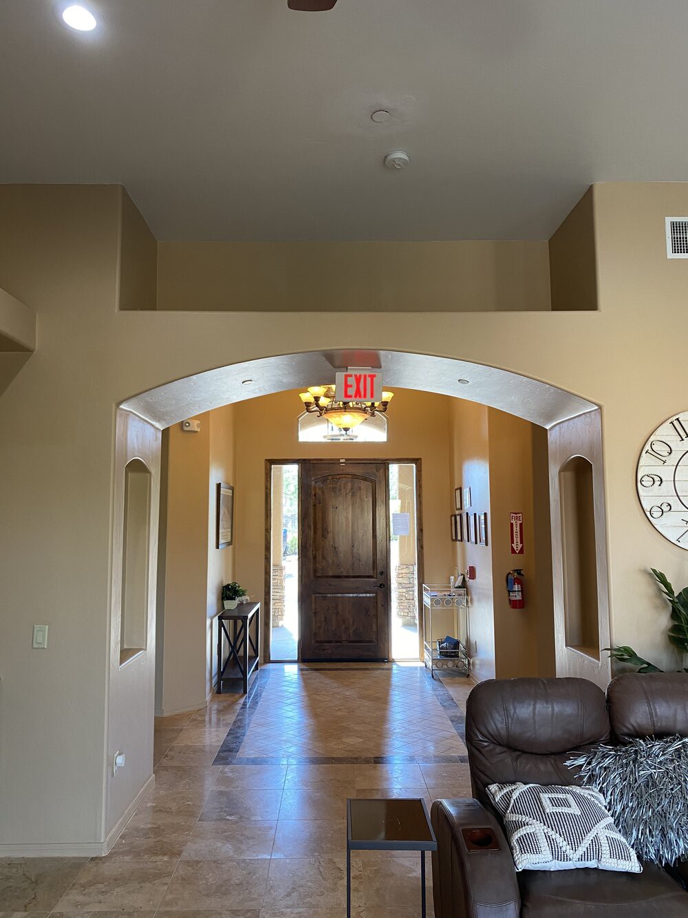 A welcoming home entrance with an archway leading to a wooden front door, surrounded by tasteful interior decor.