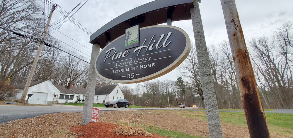 Sign of Pine Hill Retirement Home with surrounding landscape.