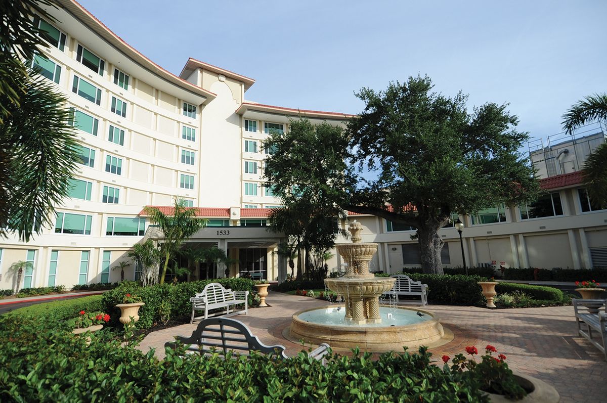 A scenic view of a hotel exterior with a fountain and garden area.