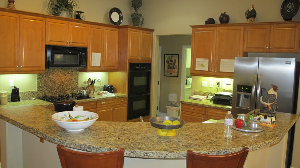 A modern kitchen with wooden cabinets and a granite countertop.