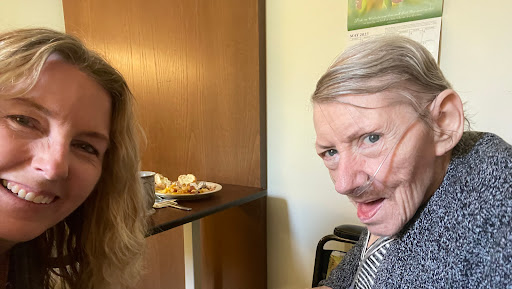 A lighthearted moment captured between two individuals, one playfully adorned with a faux mustache.