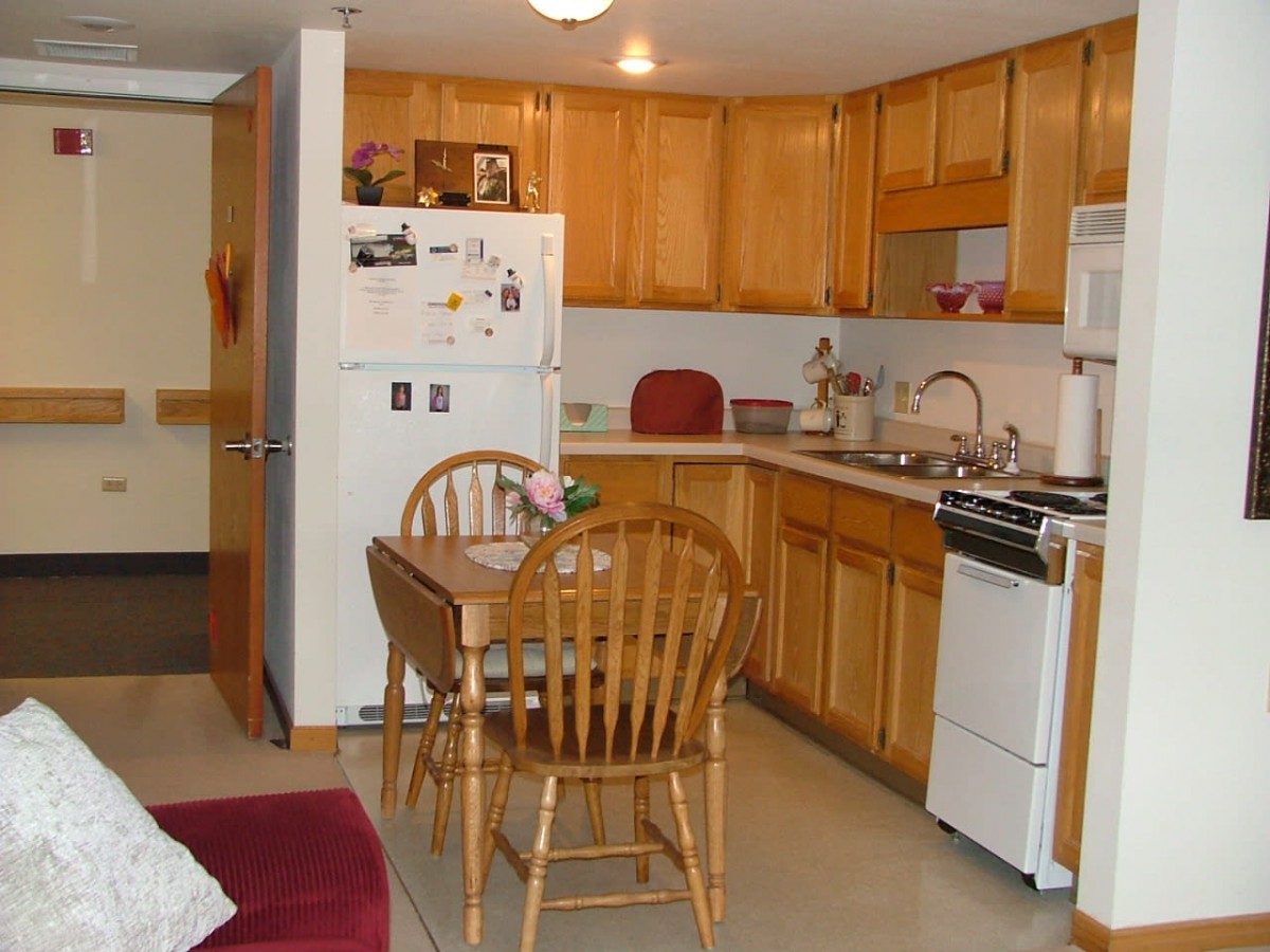 Cozy kitchen with wooden cabinets, a dining table, and essential appliances.