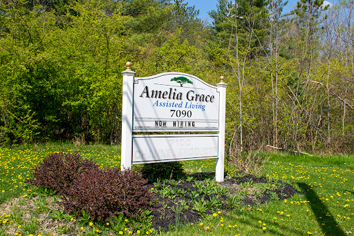 The sign of Amelia Grace Assisted Living surrounded by lush greenery.