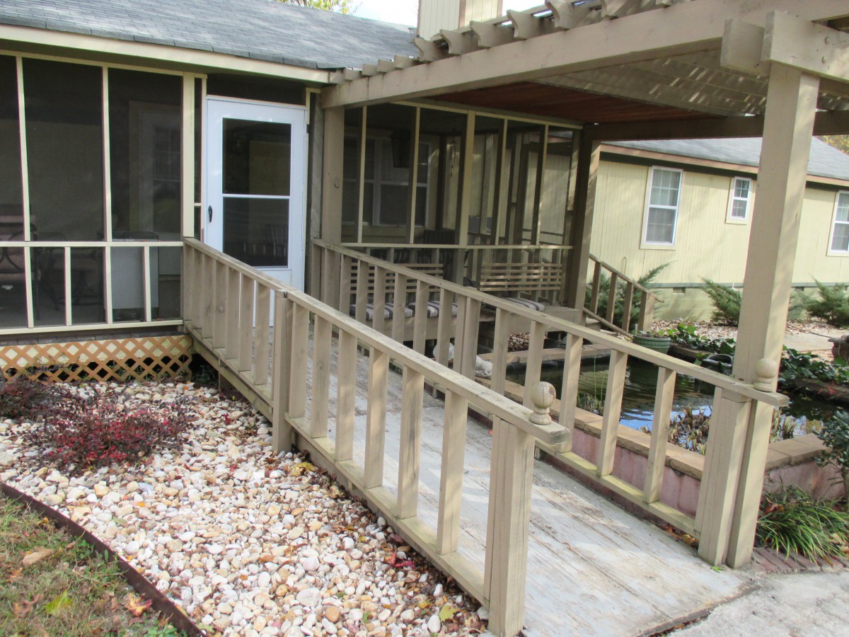 A wooden ramp leading to a screened porch at the entrance of a house, highlighting accessibility features.