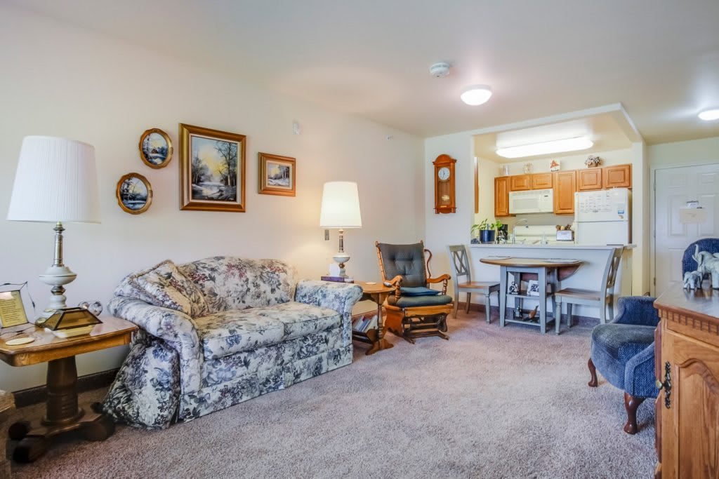 Cozy living room with floral couch and open kitchen view.