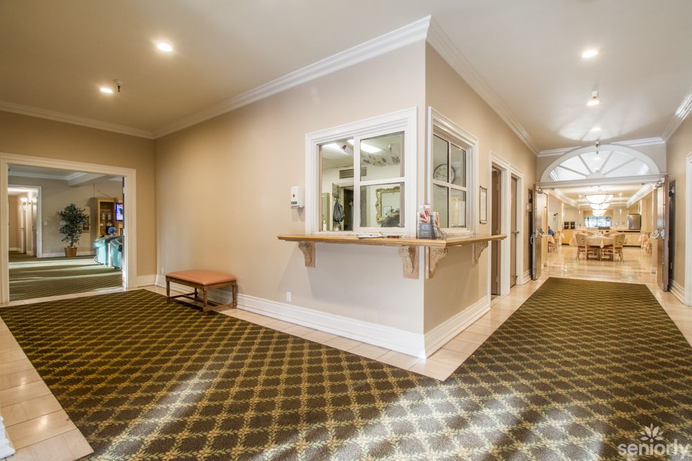 A brightly lit hallway with a reception area and carpeted floors.