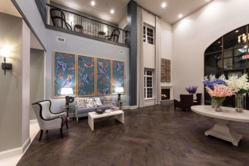 A spacious and modern living room with high ceilings, featuring contemporary artwork and elegant furniture.