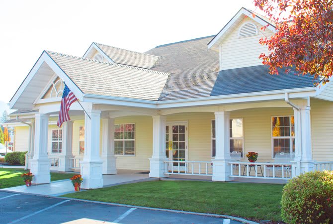 A charming residential house with a porch and an American flag.