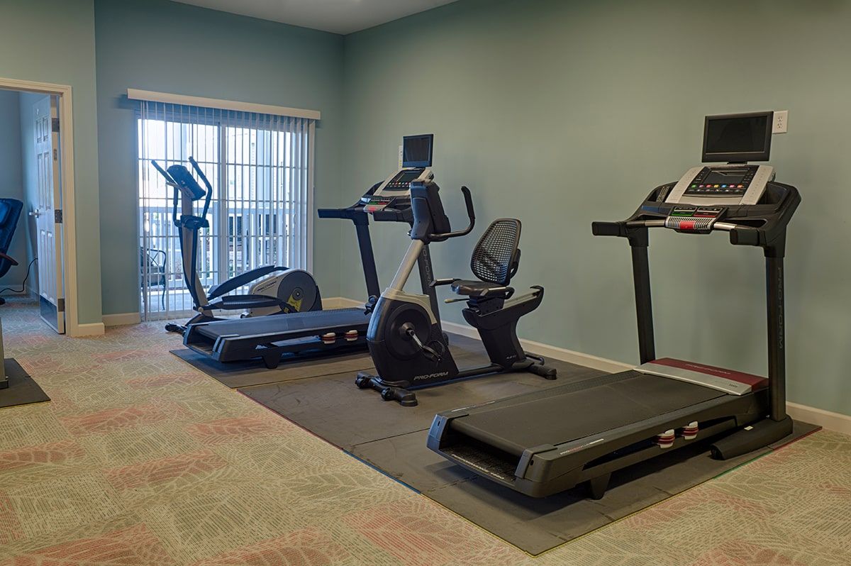 A well-equipped gym with treadmills and an exercise bike.