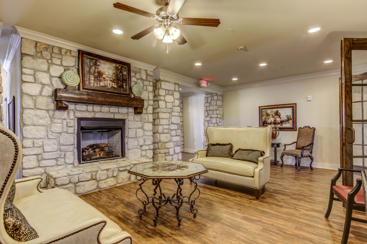 A cozy living room with a stone fireplace and comfortable seating.