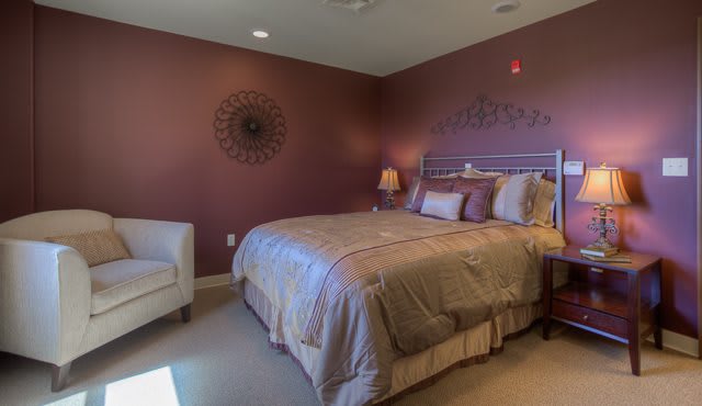 A cozy bedroom with a warm color scheme, featuring a comfortable bed and stylish decor.