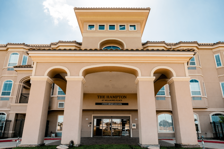 A grand building entrance with columns and a tower, captured during the daytime.