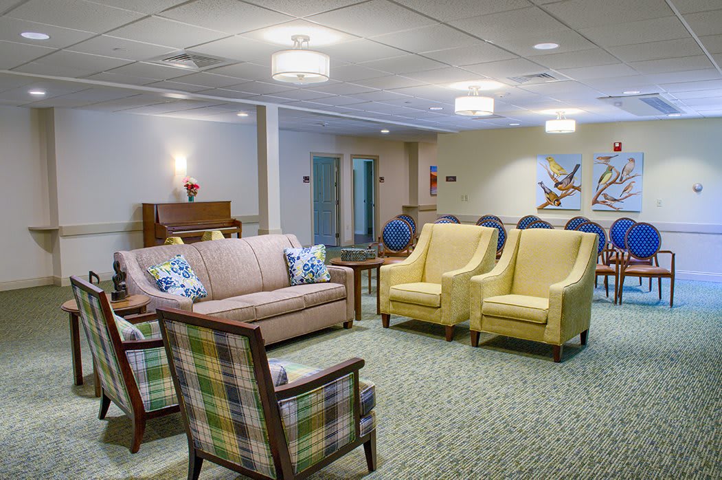 A cozy lounge area with sofas and armchairs, featuring soft lighting and inviting decor.
