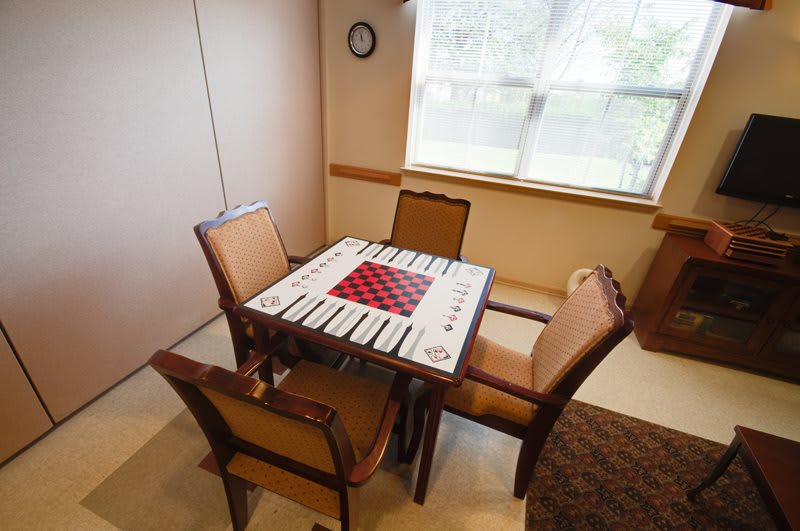 A cozy indoor room with a table and chairs set up for a game.