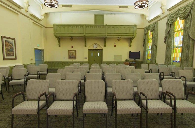 An empty meeting room with rows of chairs facing the front.