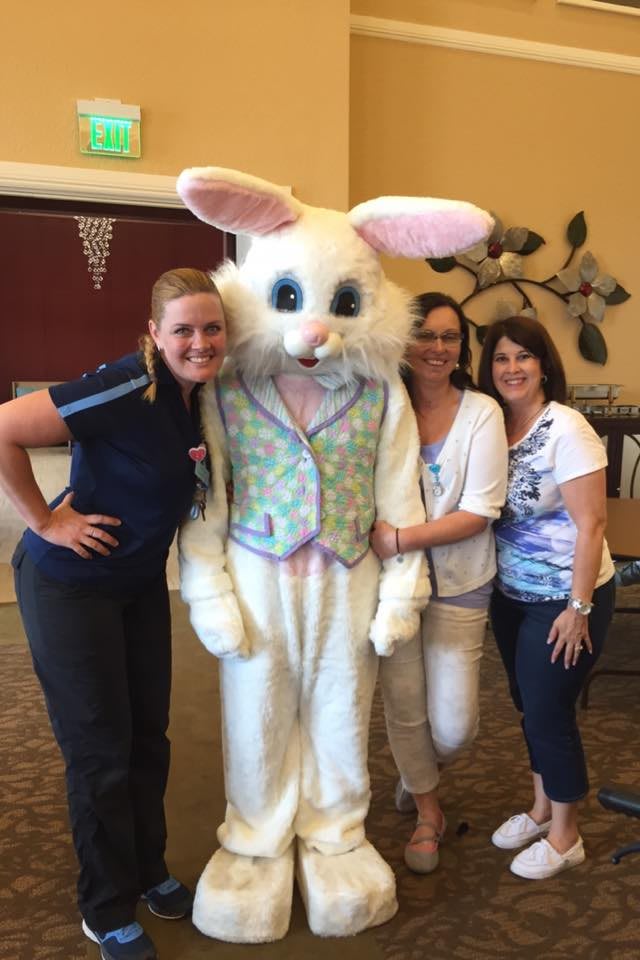 A group of people posing with a person in an Easter bunny costume.