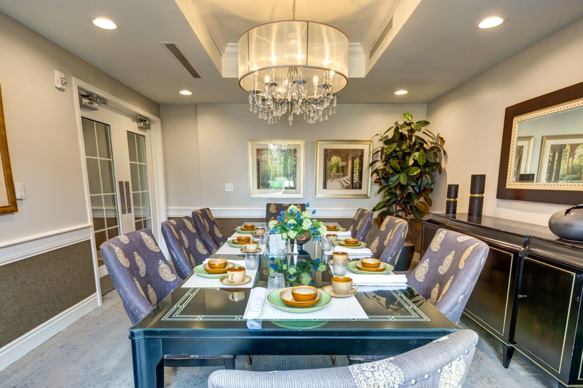 An elegantly decorated dining room with a large chandelier and sophisticated table setting.