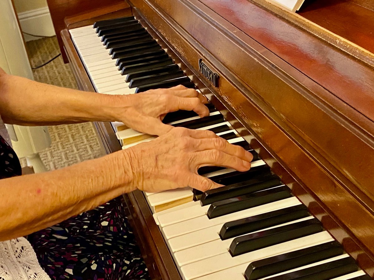Hands playing a piano.
