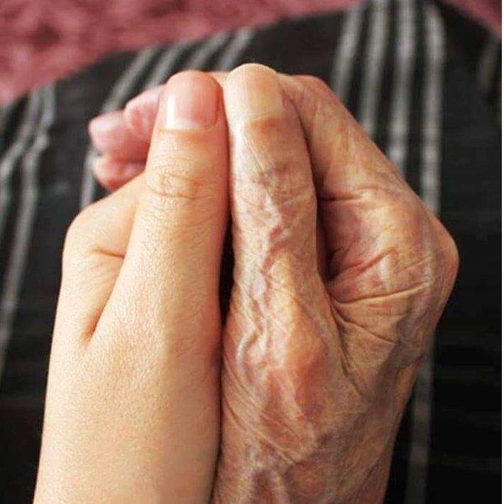 A tender moment capturing the touch of young and old hands, symbolizing connection across generations.