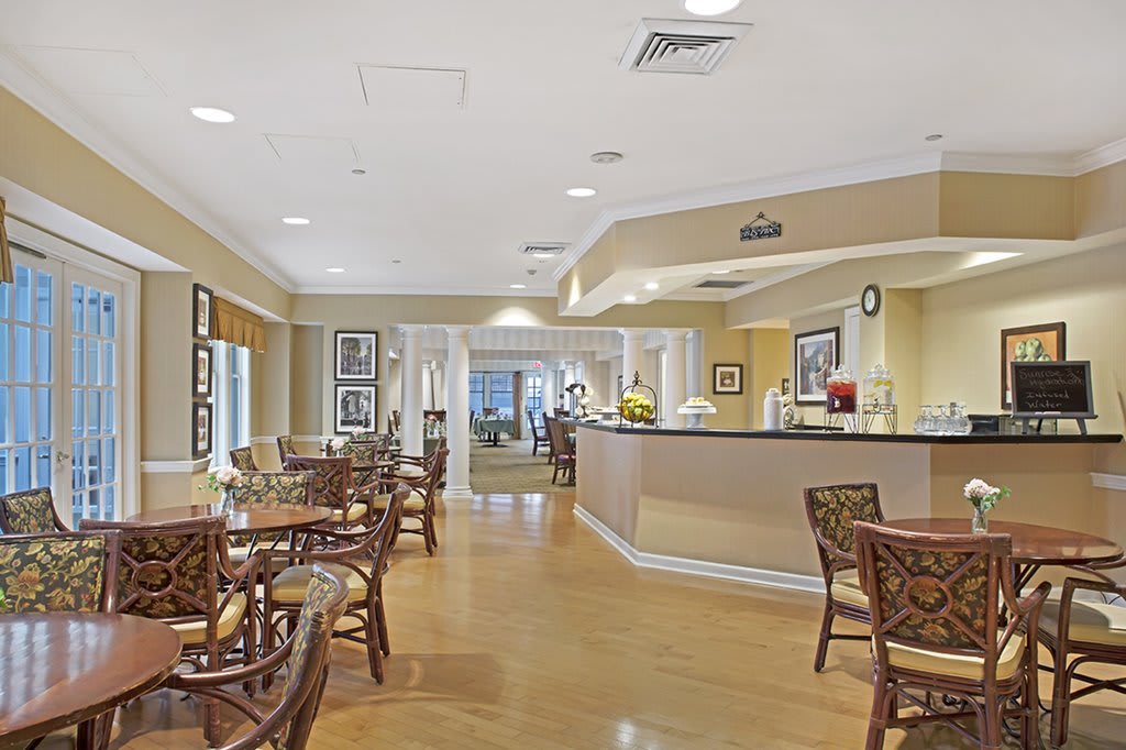 A well-lit dining area featuring multiple tables and chairs, with a clean and modern decor.