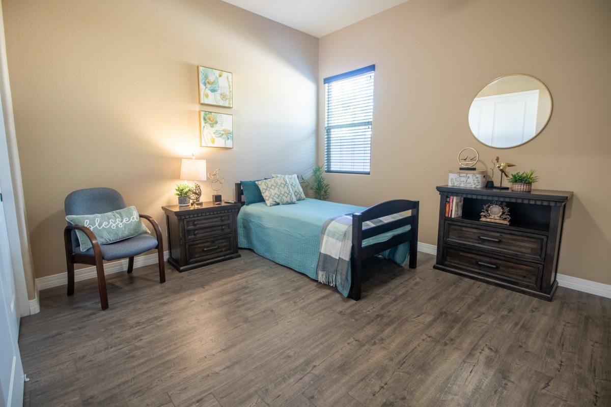 A cozy bedroom with a single bed, wooden flooring, and modern decor.