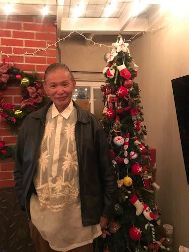 A man stands next to a beautifully decorated Christmas tree, embodying the festive spirit of the season.