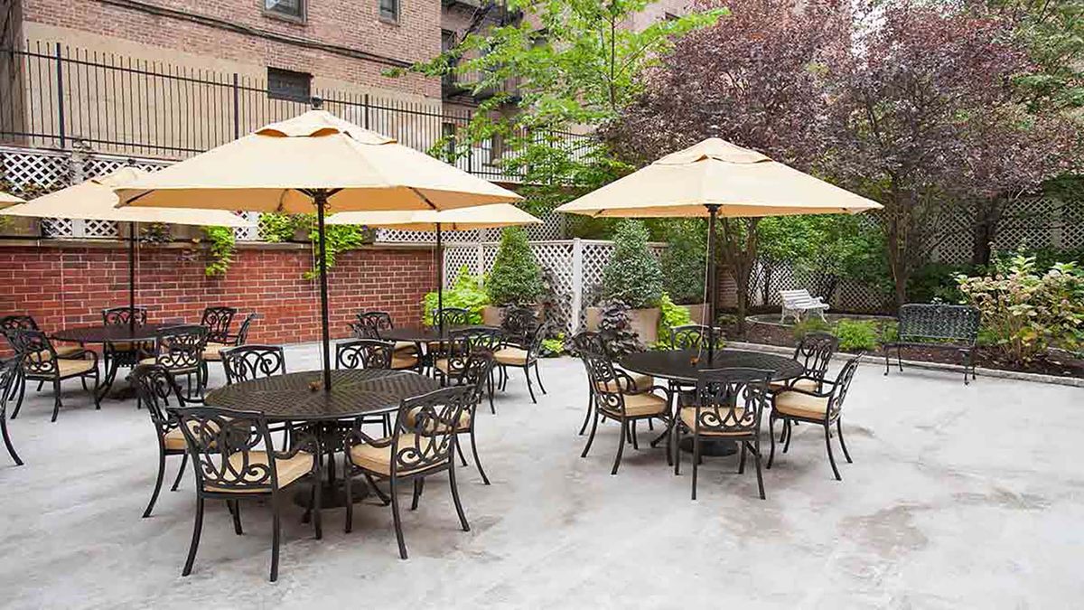 A cozy outdoor patio area with tables, chairs, and large umbrellas.