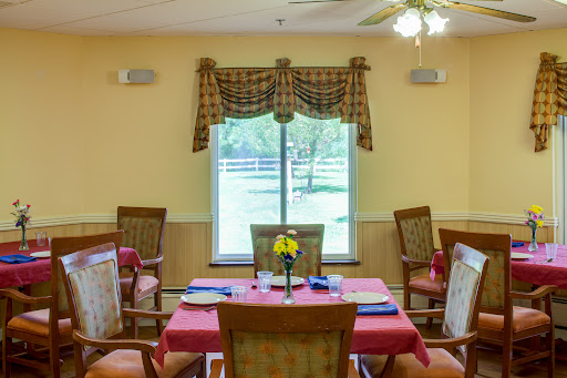 A cozy dining area with a beautifully set table, inviting natural light from the window.