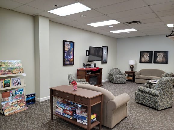 A cozy waiting room with comfortable seating, a television, and reading materials.