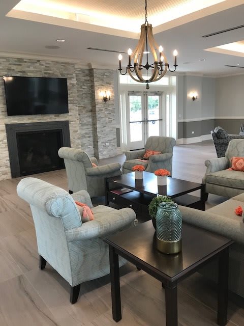 A cozy living room with plush seating, a fireplace, and a chandelier.