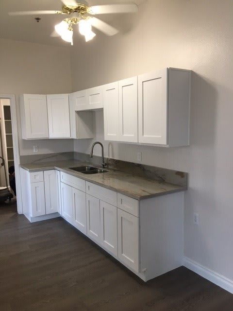 A modern kitchen with white cabinets and a sleek countertop.