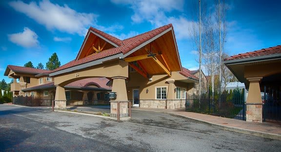 A modern building with a prominent triangular roof and a covered driveway entrance.