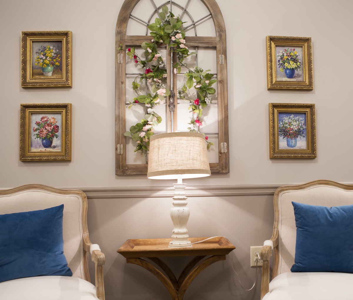 A cozy living room setting with two armchairs, a lamp, and decorative wall art.