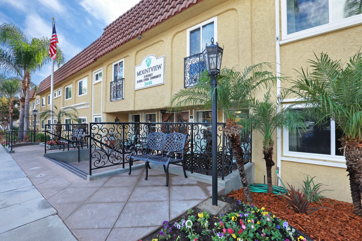A charming hotel exterior with lush landscaping and outdoor seating.