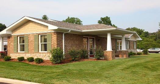 A brick house with a well-maintained lawn and garden.