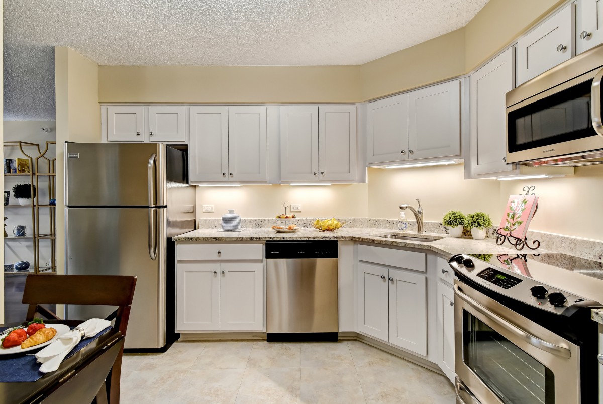 A modern kitchen with stainless steel appliances and white cabinets.