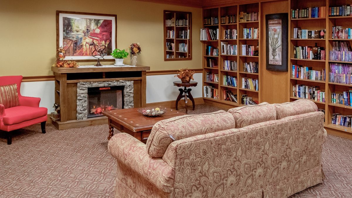 Cozy living room with a fireplace, bookshelves, and comfortable seating.