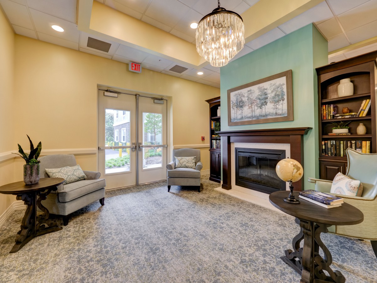 A cozy lobby area featuring plush chairs, a chandelier, and a fireplace, creating an inviting atmosphere.