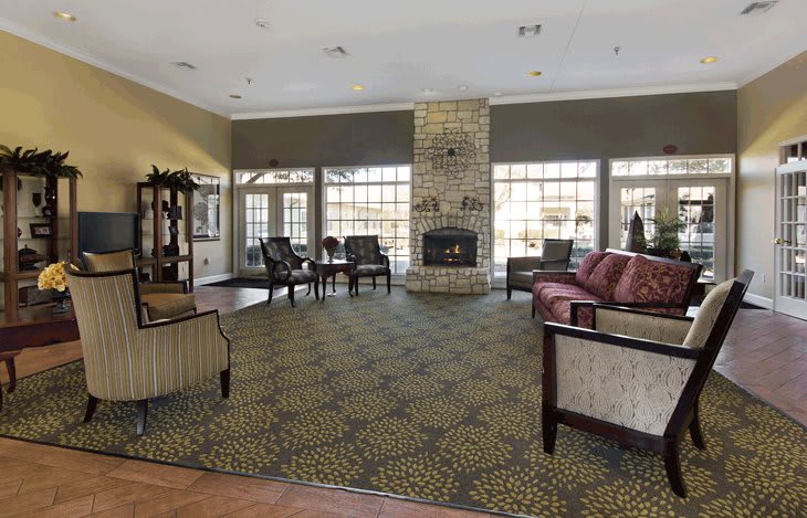 A spacious living room with a fireplace, large windows, and comfortable seating.
