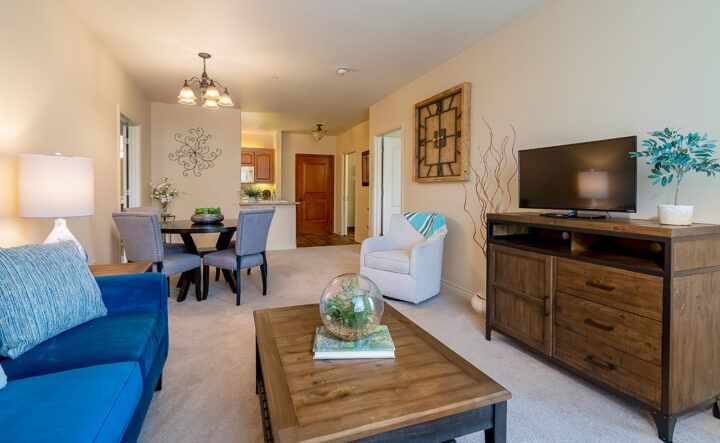 A cozy, modern living room featuring a coffee table, armchair, and dining area.